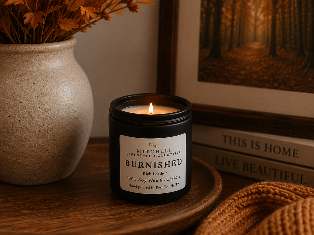Burnished rich leather soy candle, lit, in a minimalist setting