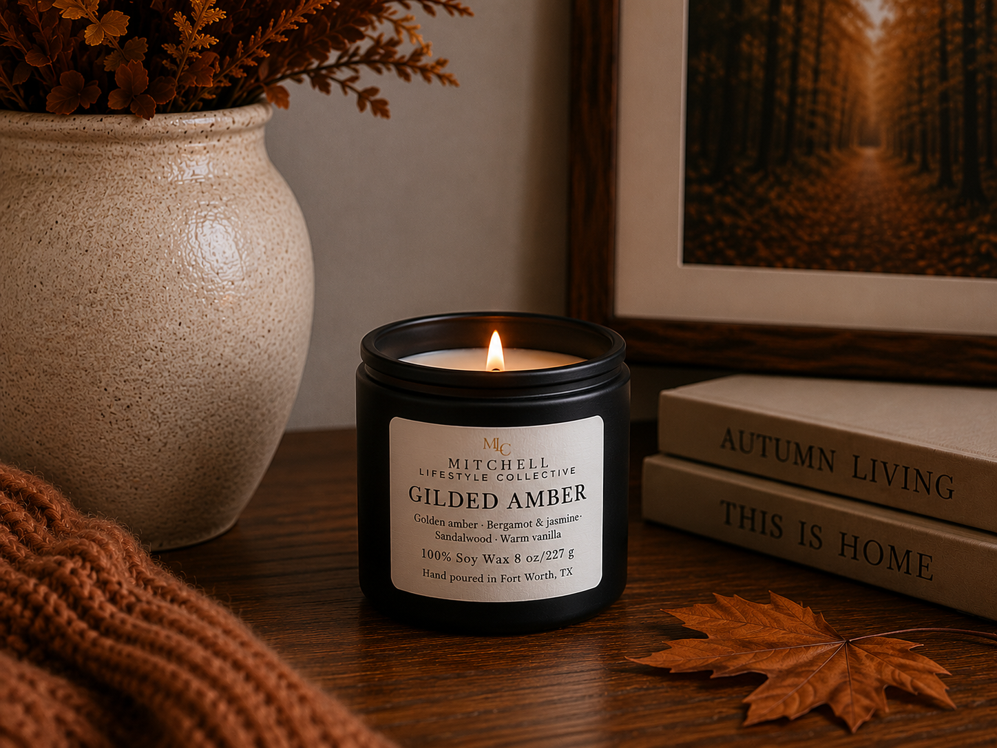 Gilded Amber soy candle in a matte vessel, lit, on a styled tabletop