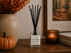 Gilded Amber reed diffuser on a wood table