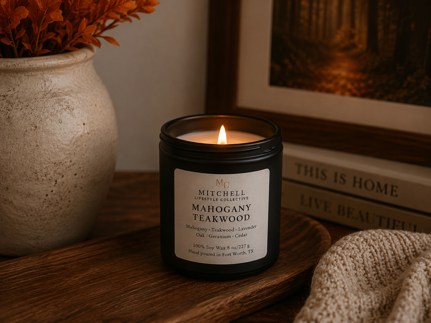 Mahogany Teakwood soy candle in a dark vessel on a shelf
