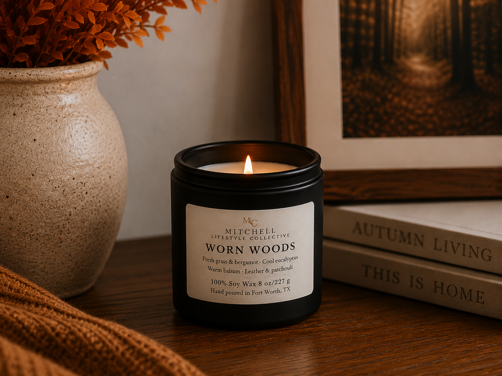 Worn Woods leather and green woods soy candle, lid off, on a wood surface