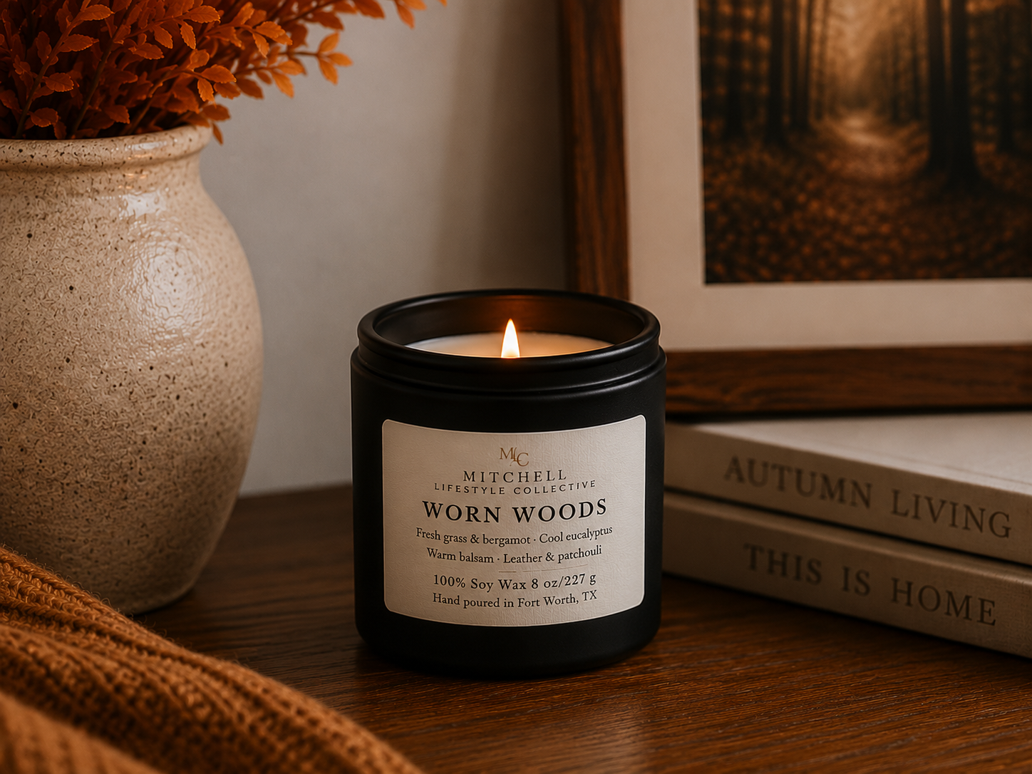 Worn Woods leather and green woods soy candle, lid off, on a wood surface